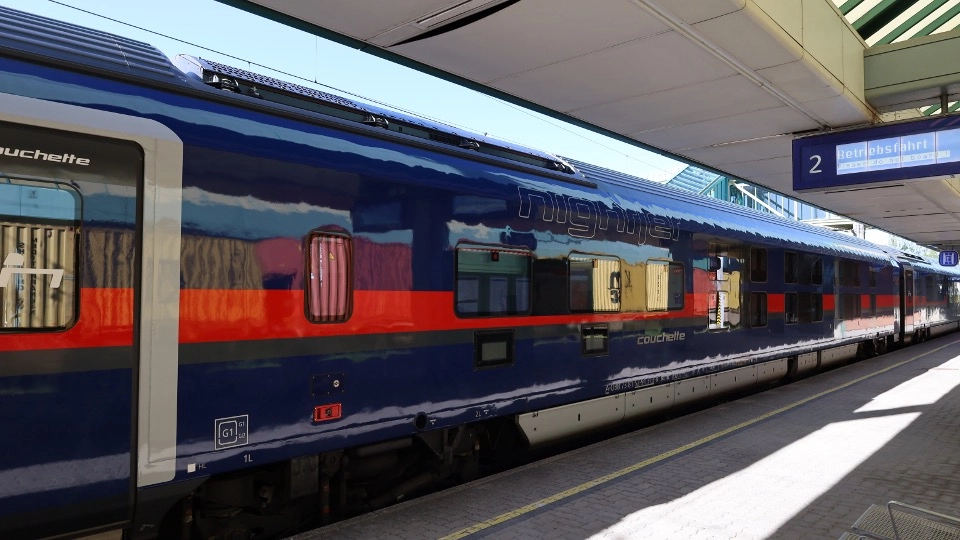 A photograph of a Nightjet train at a train station.